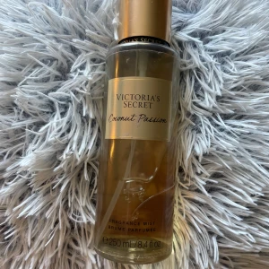 Victoria's Secret Coconut Passion mist - Fräsch body mist från Victoria's Secret i doften Coconut Passion. Flaskan är genomskinlig med guldigt lock och etikett, rymmer 250 ml men har använt så på andra bilden kan man se hur mycket de är kvar ksk 240 ml. Doften är söt och tropisk med tydliga toner av kokos och vanilj. Perfekt för dig som älskar somriga och exotiska dofter.