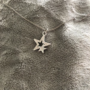 Silverhalsband med äkta silver stjärna med diamanter  - Ett tunt silverfärgat halsband med ett hänge i form av två stjärnor, dom har små diamanter i sig. Halsenbandet/kedjan är inte äkta silver, Men berlocken/ stjärnorna är äkta silver!🫶🏼