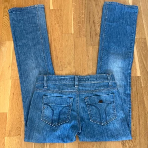 Lågmidjade jeans från Miss Sixty - Snygga blå jeans från Miss Sixty med klassisk femficksdesign och knappgylf. Perfekta för en avslappnad stil med en touch av vintagekänsla.