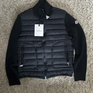 Moncler Cardigan  - Säljer en helt ny Moncler Cardigan utan luva. Den har en unik design och Moncler-logga på ärmen. Den är inte så tjock och perfekt för det kommande vädret. Priset går att diskutera vid snabb affär.