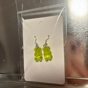 Gröna örhängen med nallebjörnsdesign - Söta gröna örhängen formade som nallebjörnar. Perfekta för att lägga till en lekfull touch till din outfit. De hänger från en enkel krok och är lätta att bära. (Billigt material) 