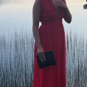 Röd långklänning med v-ringning - Röd långklänning med djup v-ringning och ärmlös design ❤️