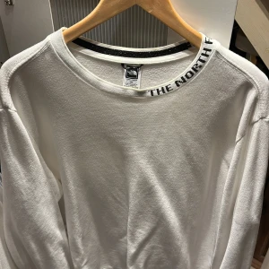  The North Face Zumu Crewneck - Vit tröja från The North Face skön i passform och längd. Jag på bilen är 202cm och har relativt långa armar. Nypris på denna modell ca:800kr 