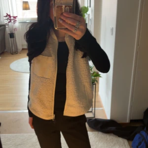 Vit mysig teddyväst - Jag säljer min lurviga teddyväst från ONLY med dragkedja och tre fickor. Perfekt för lager-på-lager under kyliga dagar. Men även snygg att ha inomhus! 💗 Västen har en enkel och stilren design. Endast använd några gånger!✨