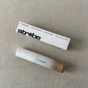 MAC Strobe Beam Liquid Blush - MAC Strobe Beam Liquid Blush i nyansen Lightning. Denna flytande rouge ger en strålande och fräsch look. Perfekt för att skapa en naturlig glöd med en lätt och byggbar formula. Ej använd, paketet medföljer 