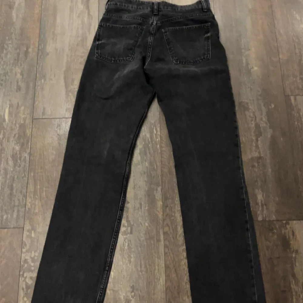 Snygga svarta jeansbyxor med hög midja och raka ben. Perfekta för en avslappnad stil. Klassisk design med fem fickor och knappgylf.. Farkut & Housut.