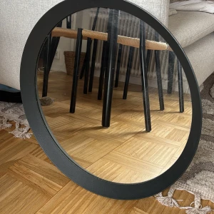 Rund spegel LANGESUND från IKEA - Säljer en stilren rund spegel från IKEA, modell LANGESUND. Spegeln har en svart ram och är tillverkad i Turkiet. Perfekt för att ge rummet en modern touch. Passar bra i hallen eller sovrummet.