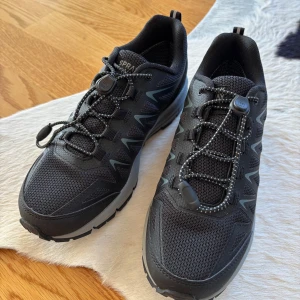 Svarta sneakers från Spray way (vattenfasta) - Snygga svarta sneakers från Spray way  med praktisk snörning och robust sula. Perfekta för både stad och natur. De har en modern design med diskreta detaljer och är gjorda för att ge bra stöd och komfort.