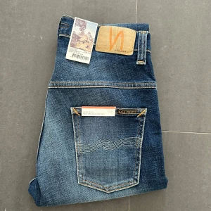 Nudie jeans - Nudie Jeans av modellen Thinn Finn Storlek: 29/28 - Skicket på jeansen är ny med prislapp - 100/10 - mitt pris: 599- Nypris: 1599kr.   En stor fördel med Nudies jeans jämfört mot Levis, Tiger of Sweden, Replay, Lee, Acne, dondup osv. Ar att du kan lämna in dem gratis for reparation eller uppläggning i Stockholm, Göteborg eller Malmö. Pa sa vis förlängs livslängden rejalt.
