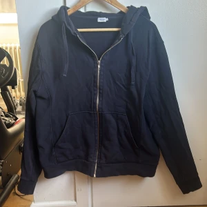 Mörkblå hoodie från Filippa K - Säljer en stilren mörkblå hoodie från Filippa K med dragkedja och huva. Perfekt för en avslappnad look. Den har långa ärmar och en klassisk passform. Ett måste i garderoben för alla hoodie-älskare!