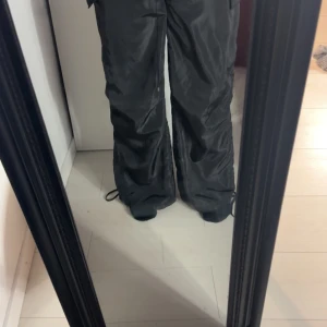 Svarta byxor från Shein - Snygga svarta byxor från Shein i en loose passform. Byxorna har en elastisk midja för extra komfort och är perfekta för en avslappnad stil. Tillverkade i ett syntetmaterial som ger en lätt och bekväm känsla. Dessa är tyvärr för små och därför säljer jag dom. Har storlek 40 i vanliga fall samt 166cm lång