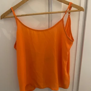 Orange linnetopp med smala axelband - Snygg orange linnetopp med smala justerbara axelband och djup rygg. Tunt och lätt material som känns luftigt och perfekt för varma dagar. 🌸🤩