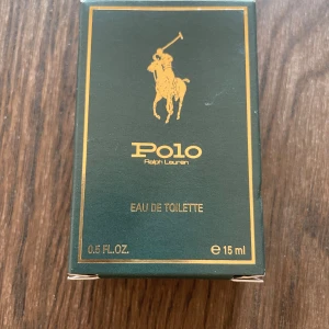 Polo Ralph Lauren Eau de Toilette 15ml - Klassisk Polo Eau de Toilette från Ralph Lauren i en elegant grön glasflaska med gulddetaljer och ikonisk logga. Flaskan rymmer 15 ml och kommer i en snygg grön kartong med guldtext. Perfekt storlek för att ta med sig och en tidlös doft med maskulin känsla.