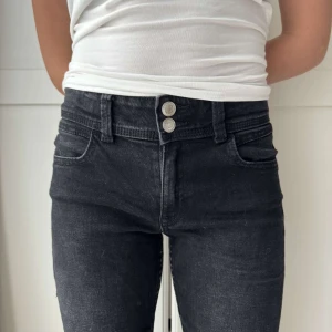 Svarta bootcut jeans  - Svarta midrise bootcut jeans med dubbla silverknappar framtill, klassiska fickor och en diskret broderad detalj på backfickan🩷 (Gina Young)