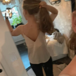 Ljusrosa linnetopp från BikBok - Supersöt ljusrosa linnetopp från BikBok med smala axelband och djup v-ringning både fram och bak. Toppen är i ett slätt, lätt material som känns skönt mot huden och har en enkel, stilren look. Perfekt att matcha med jeans eller kjol för en fräsch vibe.