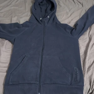 Mörkblå hoodie från Peak Performance - Säljer en mörkblå hoodie från Peak Performance i storlek S. Tröjan har dragkedja hela vägen, luva men snören är av och två stora fickor framtill. Broderad logga på ena fickan och mjukt fleecematerial på insidan. Perfekt för chill eller skola.