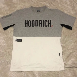 Grå Hoodrich shorts och T-shirt set  - Snygga grå shorts och tröja från Hoodrich med svarta och vita detaljer. Shorts med elastisk midja och snörning, två stora fickor med svarta dragkedjor och Hoodrich-logga på ena benet. Perfekta för chill eller streetwear. Och en mycket fin och stilren tröja, Mjukt material som känns skönt mot huden.