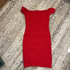 Röd offshoulder klänning  - Snygg röd kortklänning med offshoulder-modell och figurnära passform. Klänningen är tillverkad i ett stretchigt material. Köpt från en klänningsaffär i mobilia Malmö. Troligen storlek XS-S men materialet är stretchigt 