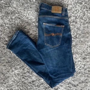 Nudie Jeans Grim Tim (Slim fit) Indigo Myth - Säljer nu dessa Nudie Jeans i den populära passformen Grim Tim | Använt men fortfarande i grymt skick | Lite slit vid benslutet (SE BILD) | Strl: W30 L32 | Färg: Indigo Myth | Nypris: ~1400kr | Hör av dig vid minsta fundering :)
