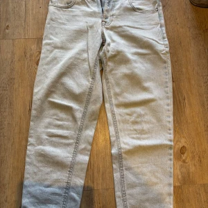 Ljusblå jeans från ASOS Design - Säljer ett par ljusblå jeans från ASOS Design med klassisk femficksmodell och raka ben. Jeansen har orangea kontrastsömmar och är tillverkade i bomull. Perfekta för en chill och stilren look.