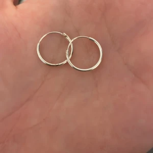 Enkla silvriga hoops örhängen - Säljer ett par klassiska hoops i äkta silver . De är tunna, runda och minimalistiska – perfekta för dig som gillar stilrena smycken. Passar till allt och är superlätta att bära hela dagen.