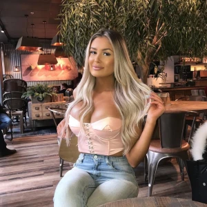 Ljusrosa korsett-topp med snörning - Trendig ljusrosa korsett-topp med snygg snörning framtill och croppad passform. Toppen har bygel och markerade kupor för extra form. Perfekt att styla med höga jeans för en cool look.