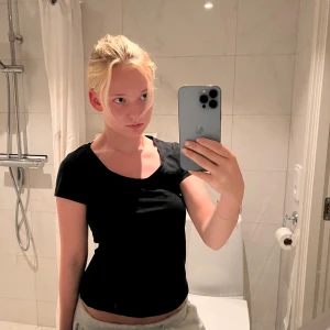 Svart basic t-shirt med rund hals - En svart, enkel t-shirt med rund halsringning och korta ärmar. Modellen är figurnära och passar perfekt till jeans eller shorts. Tillverkad i mjukt bomullsmaterial som känns skönt mot huden.