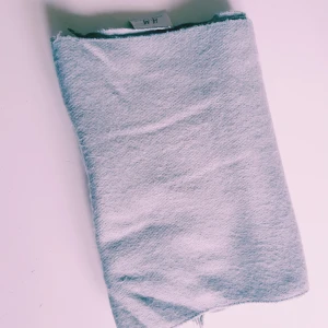 Ljusgrå halsduk från H&M - Enkel och stilren ljusgrå halsduk från H&M. Halsduken är rektangulär, har fransar i kanterna och är gjord i ett mjukt material som känns skönt mot huden. Perfekt att slänga över axlarna när det är kyligt ute.  Helt & fint skick