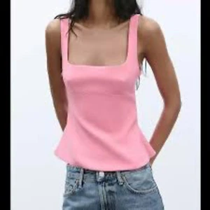 Rosa linnetopp med rosett i ryggen - Supersöt rosa linnetopp med fyrkantig urringning och breda axelband. Toppen har en öppen rygg med en stor dekorativ rosett som ger en extra touch. Perfekt till jeans eller kjol för en trendig look. Materialet känns mjukt och följsamt. Endast använd en gång💗