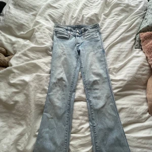 Ljusblå bootcut jeans  - Snygga ljusblå jeans med bootcut-modell och dubbla knappar i midjan. 