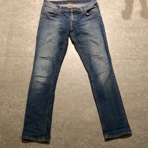 Nudie jeans med slitningar - Schyssta Tube Kelly Nudies i en slim fit. Storlek 31/32 måtten är 43, 106/77, 18. Modellen är 178, 65kg. Riktigt snygg design med slitningarna vid knäna och gillar verkligen att strecken på baksidan är med vit söm. Skickar snabbt och skriv vid minsta fråga. Liknande och annat finns på profilen!😁