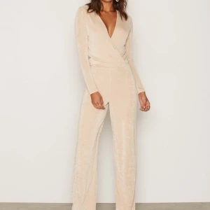 Champagnefärgad glittrig jumpsuit  - Glittrig champagnefärgad jumpsuit från Nelly. Helt oanvänd. 