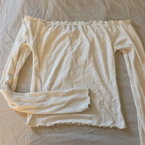 Vit ribbad offshoulder topp från FB Sister - Säljer en vit ribbad offshoulder topp från Newyorker. Toppen har långa ärmar och en elastisk kant upptill för en bekväm passform. Perfekt för en stilren look. Storlek XXS!🥰