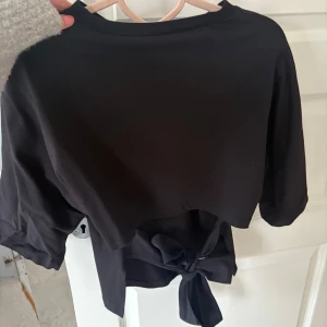 Knyttopp från Nelly - Populär svart topp man knyter i ryggen från Nelly ! Använd en gång så i väldigt fint skick! Kom Med prisförslag ☺️