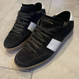  Saint Laurent SL/10 - Ett par svarta saint lauren skor i storlek 42 men är lite stora i storleken. Skick 8/10 då de är lite använda. De är lite blå på vita delen på baksidan men inget så illa som ni kan se på bilderna. Skriv om ni har någon fråga!