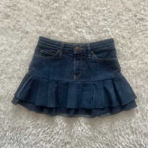 Jeanskjol med volang - En lågmidjad jeanskjol omsydd från ett par jeans. Midjemått tvärsöver - 33cm stretchig  Längd - 33 cm