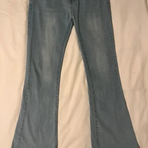 Ljusblå bootcut jeans - Snygga ljusblå medel/högmidjade bootcut jeans i en skön mix av bomull och polyester. Storlek M och mycket bra skick. Vet tyvärr ej varumärke.