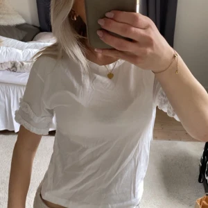 Vit t-shirt med volangdetaljer - Säljer en söt vit t-shirt med volangdetaljer på ärmarna💕💕Finns ingen lapp men tror att den är strl S 