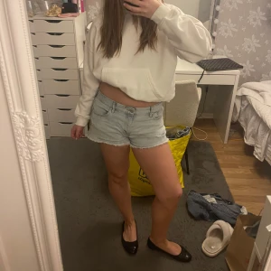 Lågmidjade ljusblå jeansshorts - Säljer ett par ljusblå jeansshorts med en klassisk design. De har en låg midja och en avslappnad passform som är perfekt för varma dagar.