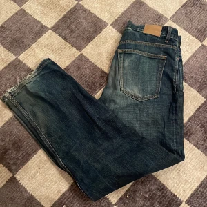 Blå jeans från Weekday - Säljer ett par blå Galaxy Loose Straight Jeans från Weekday. De har en klassisk femficksdesign och en avslappnad passform. Perfekta för en casual look.