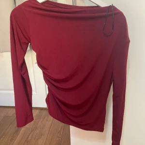 Vinröd volang tröja - En röd volang tröja ifrån H&M i storlek S. Helt oanvänd