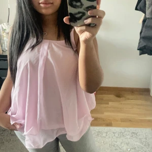Ljusrosa ärmlös blus - Säljer en ljusrosa ärmlös blus med lös passform. Ganska tunn. Endast använd ett fåtal gånger