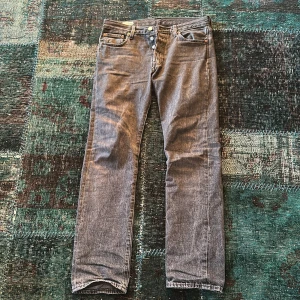 Grå Levis 501 jeans - Säljer ett par klassiska grå Levis 501 jeans. De har en rak passform med knappgylf och fem fickor. Perfekta för en avslappnad stil. Storlek W30 L32