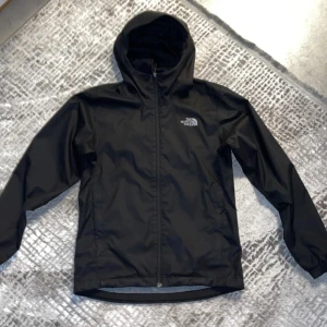 Svart vindjacka från The North Face (pris kan diskuteras) - Säljer en svart vindjacka från The North Face med huva och dragkedja. Jackan är tillverkad i DryVent-material som är perfekt för blåsiga dagar. Den har långa ärmar och elastiska muddar för extra komfort. Perfekt för utomhusaktiviteter! Ja har bara använt jackan ett par gånger då den inte passar mig. Jackan är i storlek S men kan också användas som strl M.