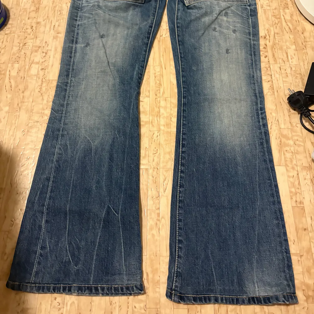 Snygga blå jeans från Hilfiger Denim med en klassisk femficksdesign och slitna detaljer. Byxorna har en låg midja och bootcut-stil, säljer eftersom att de är för korta, men i perfekt skick! Pris kan diskuteras. Farkut & Housut.