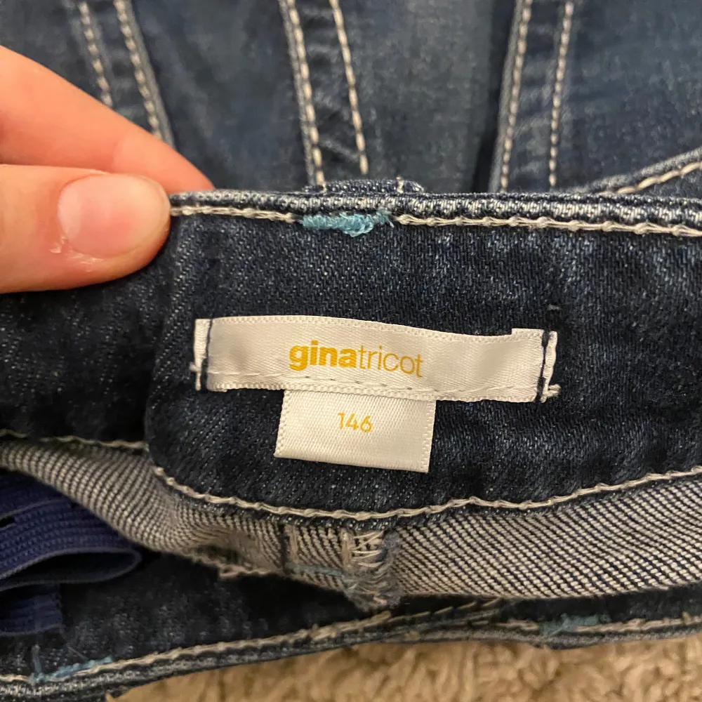 Snygga blå bootcut jeans från Gina Tricot med klassisk femficksdesign och dekorativa sömmar. Perfekta för en avslappnad stil med en touch av retro. Passar utmärkt till både sneakers och klackar.. Farkut & Housut.