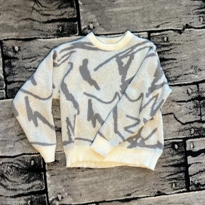 Vit stickad tröja med mönster - Säljer en vit och grå stickad tröjs med abstrakt mönster. Tröjan har långa ärmar och en rund hals. Storlek S. Pris kan diskuteras vid snabb affär. 