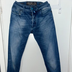 Jacob Cohen Jeans 688 - Snygga blå jeans från Jacob Cohen med en klassisk femficksdesign. De har en normal passform och en dragkedja framtill. Perfekta för en avslappnad stil. Avklippta ner till men annars som nya. Modellen är 688:)