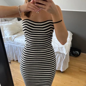 Randig klänning - Superfin bandeu-klänning från Gina. Klänningen har en tight passform och är knälång, perfekt för en stilren look. Den är superstretchig i materialet och klänningen är endast använd ett fåtal gånger☺️