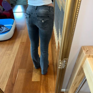 Grå jeans med fickdetaljer - Snygga grå jeans med dekorativa fickor och knappar bak. De har en klassisk passform och är perfekta för en avslappnad stil. Passar bra till både sneakers och boots. Jag är 173 cm för referens 